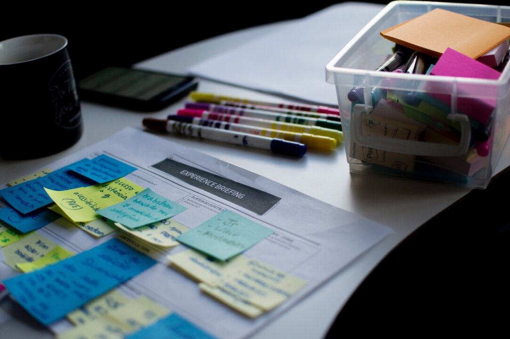 Photo by Felipe Furtado - table with postit notes and markers. Experience briefing and process steps